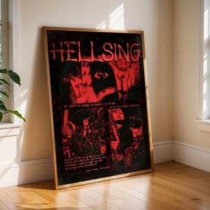 May include: A framed poster with the word "HELLSING" in red letters against a black background. The poster features red and black illustrations of characters and text. The frame is gold-colored, and the poster is leaning against a wall.