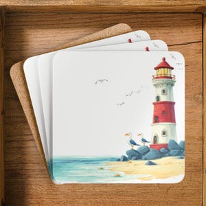May include: Square coasters with a coastal design. Each coaster features a watercolour illustration of a red and white lighthouse, seagulls, and the sea. The coasters are stacked on a cork base.