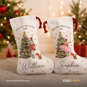 May include: Two off-white fabric Christmas stockings with red drawstring ties. Each features the text "SPECIAL DELIVERY FOR" above a Christmas tree, gifts, and gold stars. One displays a nutcracker, the other a ballerina, with names William and Sophia.