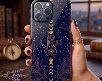 May include: A dark blue smartphone case featuring a gold-toned graphic of a hamsa hand with an eye at the centre, surrounded by celestial moon phases, stars, constellations, and botanical sprigs. The design is printed on a glossy, smooth surface.