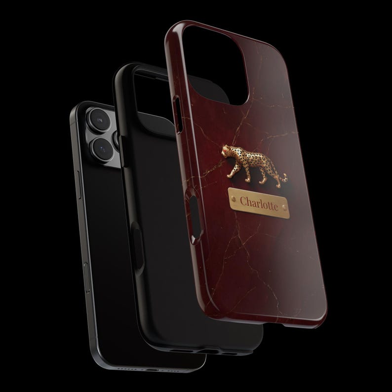 May include: A dark red marble-patterned phone case featuring a gold-toned leopard figurine and a rectangular gold nameplate with the name Charlotte engraved in the center. The case is shown layered over a black phone and a black inner protective shell.