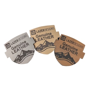 May include: Three brown leather labels with the text "D LAZER DESIGNS Genuine Leather" and a mountain silhouette.