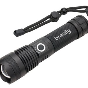 Op de afbeelding: Een zwarte zaklamp met een getextureerde grip en een zwarte polsband. De zaklamp heeft een knop aan de zijkant en het woord "breally" staat op de behuizing gedrukt.