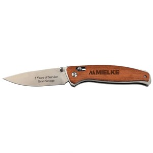 May include: A brown wooden handled pocket knife with a stainless steel blade. The knife has the words "MIELKE" and "5 Years of Service Brad Savage" engraved on it.