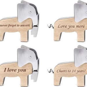 Puede incluir: Cuatro abridores de botellas de madera con forma de elefante con diferentes mensajes grabados: "never forget to uncork", "Love you more", "I love you" y "Cheers to 14 years!"