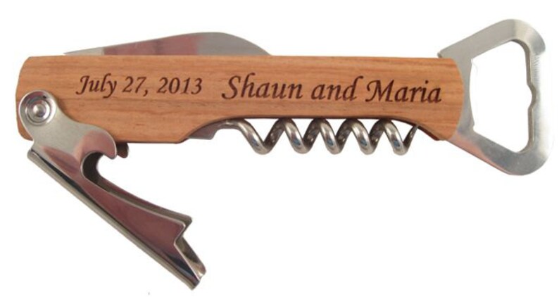 K&ouml;nnte beinhalten: Ein Flaschen&ouml;ffner mit einem Holzgriff, einem Korkenzieher und einem Flaschen&ouml;ffner. Der Griff ist mit dem Text "July 27, 2013 - Shaun and Maria" graviert.