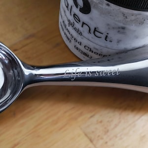 May include: A silver ice cream scoop with a heart-shaped scoop and a handle that says "life is sweet".