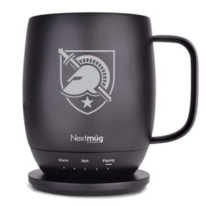 Könnte beinhalten: Ein schwarzer Nextmug mit Griff und Ladestation. Der Becher hat ein graues Emblem mit Helm, Schwert und Stern. Die Basis hat Einstellungen für warm, heiß und kochend. Der Becher ist so konzipiert, dass Getränke die gewünschte Temperatur behalten.