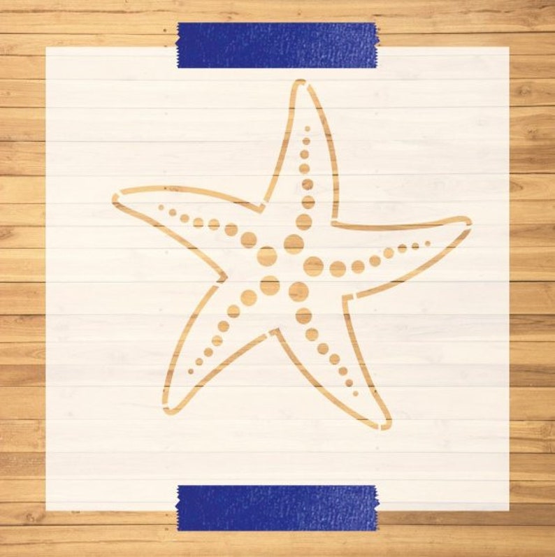 May include: A white stencil of a starfish with a dotted pattern. The stencil is on a wood background.