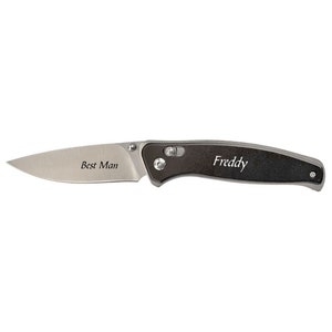 May include: A silver and black pocket knife with the words "Best Man" and "Freddy" engraved on the blade and handle. The knife has a pointed blade and a textured black handle with silver accents.