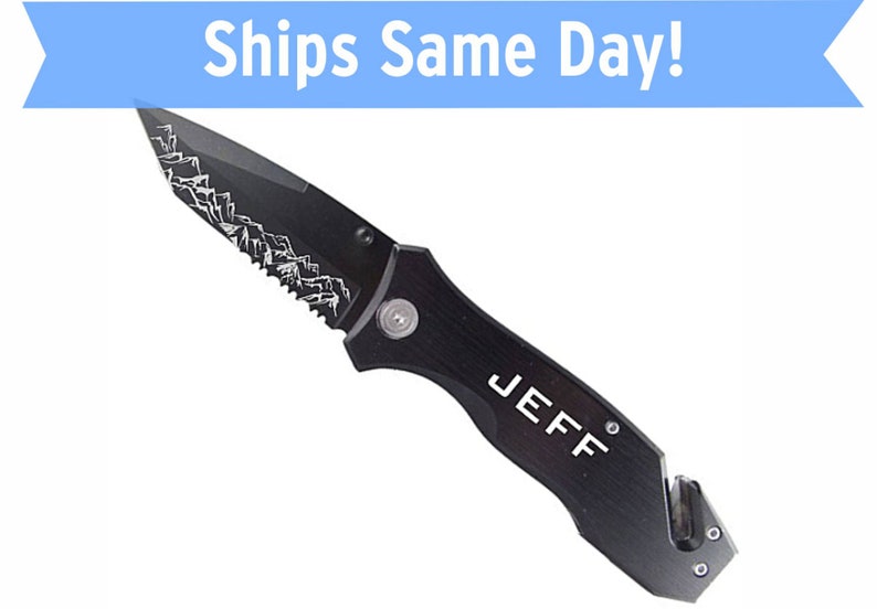 May include: Black pocket knife with a serrated blade and a safety feature. The knife has a mountain design on the blade and the name "JEFF" engraved on the handle.