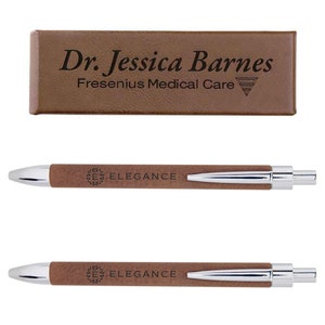 May include: A brown leather pen with a silver clip and a silver tip. The pen has the word "Elegance" engraved on it, along with a logo. The pen comes in a brown leather box with the name "Dr. Jessica Barnes" and "Fresenius Medical Care" engraved on it.