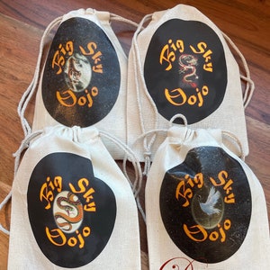 May include: Four white drawstring bags with black circles containing the text "Big Sky Dojo" and an image of a tiger, dragon, snake, and bird.
