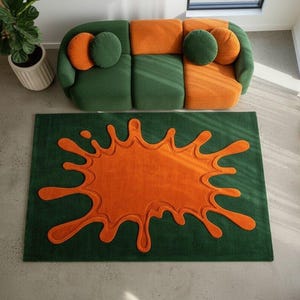 May include: A contemporary living space with a green and orange modular sofa, a green rug with an orange splash design, and a potted plant. The rug's design adds a playful touch to the room's decor.