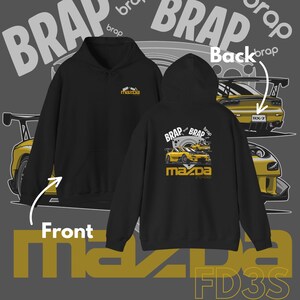 May include: Black hoodie with a front logo and a back graphic featuring a yellow sports car and the text "BRAP" and "mazda". The design includes the text "FD3S".