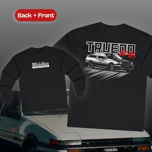 May include: Black long-sleeve shirt with white text reading "Fujiwara Tofu Shop" and a graphic of a car on the back. The back of the shirt has the word "TRUENO" above a car graphic and the text "#86".
