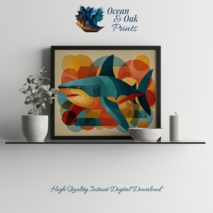 May include: A framed art print featuring a stylized shark in teal, orange, and red against a backdrop of colorful geometric shapes. The artwork is displayed on a shelf with a small plant, a bowl, and a candle. The text "Ocean & Oak Prints" and "High Quality Instant Digital Download" are visible.