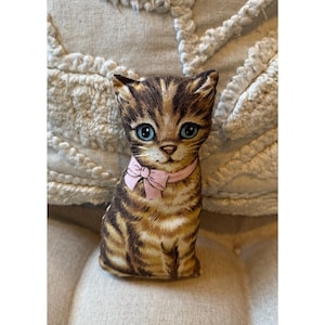 May include: A set of three ceramic mugs with a speckled, matte finish. The mugs are in shades of cream, light gray, and dark gray. Each mug has a simple, minimalist design and a rounded handle.