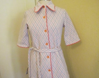 May include: A white and pink checkered shirt with orange trim and buttons. The shirt has a collar and a belt.