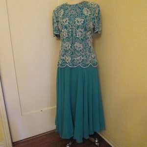 May include: A teal blue formal dress with a white beaded top and a flowing skirt.