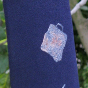 May include: Navy blue tie with repeating abstract designs in white and light blue. The tie has the initials "HJP" printed in gold. The tie is made of a smooth fabric and is suitable for formal or business attire.