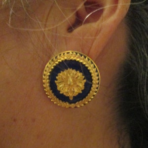 May include: Gold and blue round earrings with a floral design.