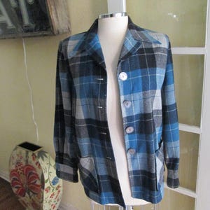 Puede incluir: Chaqueta a cuadros azul, negra y gris con tres botones y dos bolsillos. La chaqueta se exhibe en un maniqu&iacute;. La chaqueta tiene un dise&ntilde;o cl&aacute;sico y a medida.