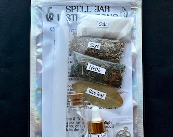 May include: A spell jar kit in a clear, resealable bag. The kit includes a white candle, small glass bottles, herbs labeled "Salt", "Sage", "Nettle", and "Bay leaf", a bottle of "Yon Veil Spell Oil", and a pentacle charm.