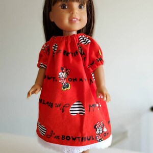 May include: A red dress with a white lace trim and a Minnie Mouse print. The dress has black stripes and hearts and the text "I'm Bowtiful" and "Oh My"