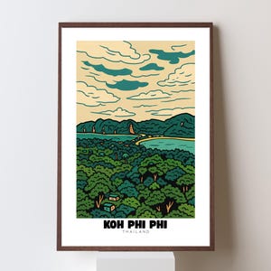 May include: A framed art print showing a landscape of Koh Phi Phi, Thailand. The image features a green forest, turquoise water, and teal clouds against a beige sky. The text "KOH PHI PHI THAILAND" is at the bottom of the print.