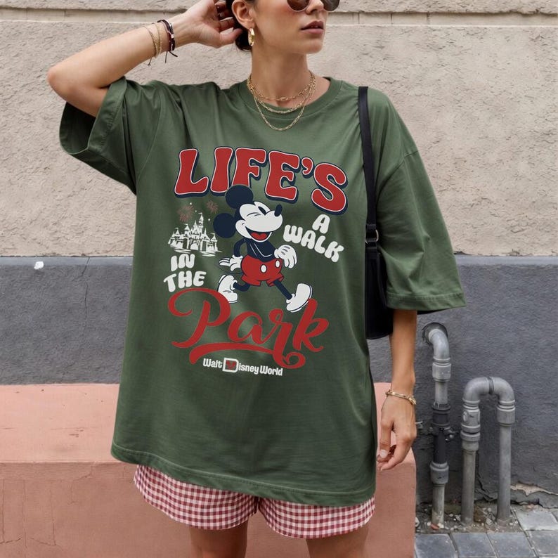 Pu&ograve; includere: T-shirt verde oliva con Topolino e la scritta "LIFE'S A WALK IN THE PARK" in rosso e bianco. La maglietta &egrave; abbinata a pantaloncini a quadri rossi e bianchi. &Egrave; stampata anche la scritta "Walt Disney World".