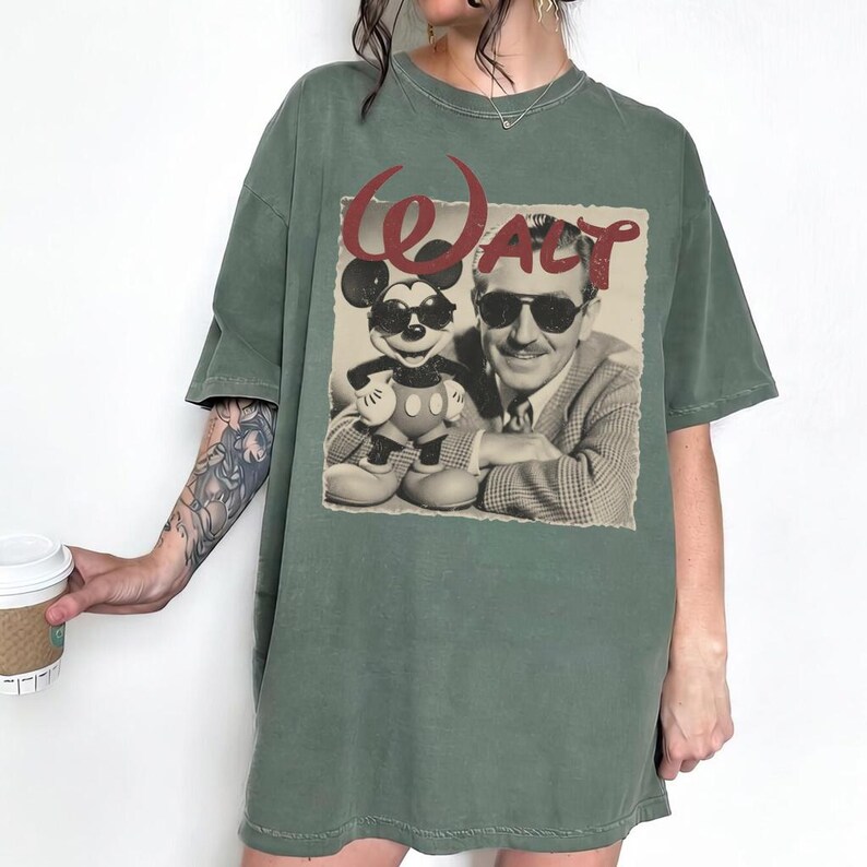 Pu&ograve; includere: T-shirt verde con grafica vintage di Topolino e Walt Disney con occhiali da sole. La parola "Walt" &egrave; stampata in rosso sopra l'immagine. La maglietta ha maniche corte e una vestibilit&agrave; ampia.