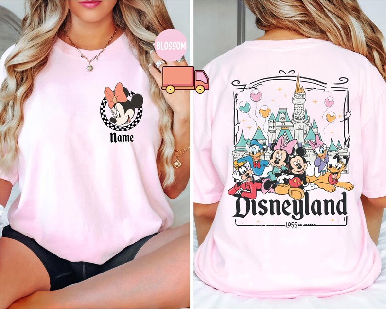 May include: Pale pink t-shirt with a Minnie Mouse graphic and the word "Name" on the front. The back shows a Disneyland design with Mickey Mouse, Donald Duck, and other characters, plus the text "Disneyland 1955."