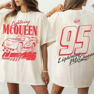 Puede incluir: Camiseta de color marfil con un gr&aacute;fico rojo del coche de carreras Lightning McQueen y el n&uacute;mero 95. La parte delantera de la camiseta tiene el texto "Lightning McQueen" y "Think Fast". La parte trasera tiene un gran n&uacute;mero 95 rojo y "Lightning McQueen".