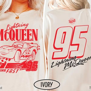 Puede incluir: Camiseta de manga larga color marfil con un gr&aacute;fico rojo de Lightning McQueen y el n&uacute;mero 95. El dise&ntilde;o frontal incluye el texto "Lightning McQueen" y "Think Fast". La parte trasera muestra un gran "95" rojo y "Lightning McQueen" en cursiva.