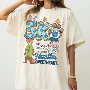 May include: A white ceramic mug with a black handle and the text "But First, Coffee" in a black, bold font. The mug is on a white surface.