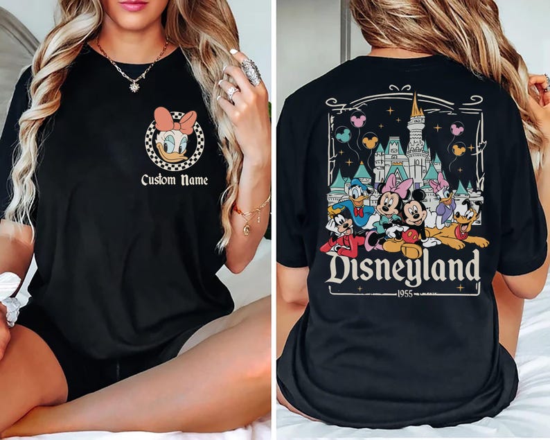 May include: Black t-shirt with Daisy Duck in a pink bow within a chequered circle, and the text "Custom Name". The back shows a Disneyland graphic with Mickey, Minnie, Donald, and Daisy Duck, and the text "Disneyland 1955".