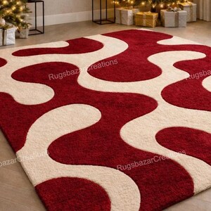 Puede incluir: Una alfombra rectangular con un dise&ntilde;o abstracto y audaz. La alfombra presenta un fondo rojo intenso con formas fluidas de color marfil. El dise&ntilde;o crea un contraste llamativo, adecuado para una sala de estar o dormitorio. Medidas en cent&iacute;metros.