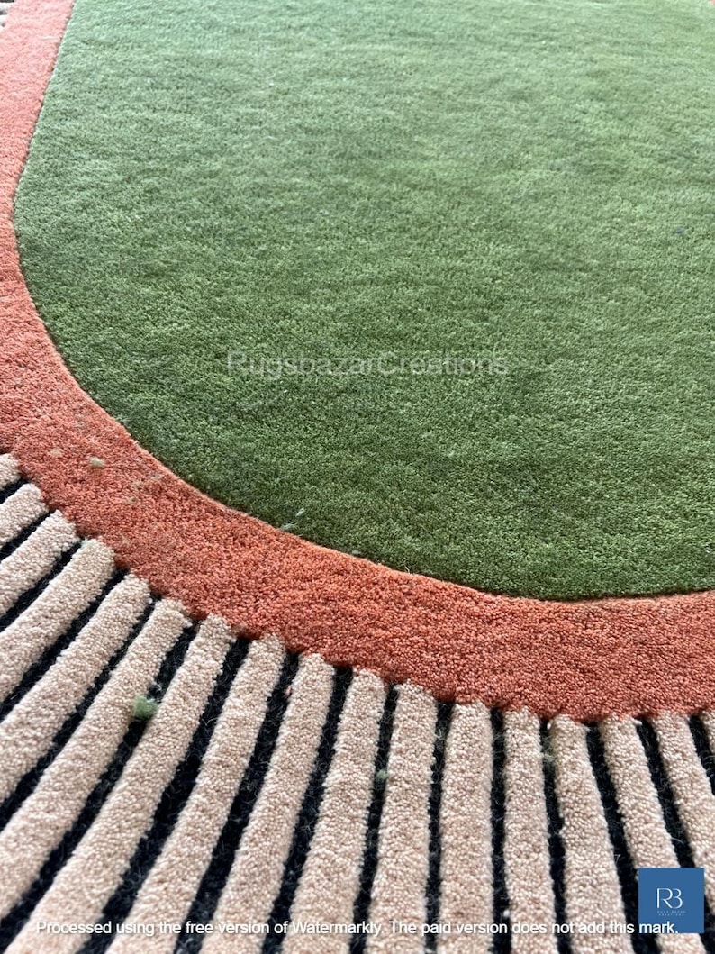 May include: A round rug with a green center, bordered by a rust-colored band and a section of beige and black vertical stripes. The rug has a textured, plush appearance. The text "RugsbazarCreations" is visible.