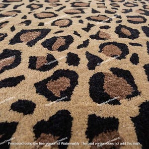 Puede incluir: Primer plano de una alfombra beige con estampado de leopardo. La alfombra presenta manchas negras y marrones sobre un fondo beige. La textura de la alfombra es visible, lo que sugiere un material suave.