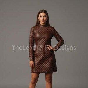 May include: A brown, long-sleeved dress with a quilted pattern. The dress has a high neckline and a fitted silhouette. The text "TheLeatherFarDesigns" is visible on the dress. The dress is made of a leather-like material.