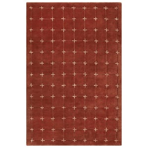 Pode incluir: Um tapete retangular em um tom marrom-avermelhado quente, apresentando um padrão de grade de costuras brancas em forma de cruz. O design do tapete é simétrico, com as cruzes espaçadas uniformemente na superfície. Um item de decoração.