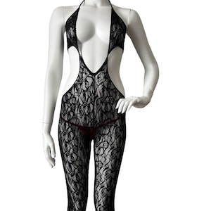 May include: Black lace bodysuit with a halter neck and open back design. The one-piece garment features a floral pattern and is displayed on a mannequin. The bodysuit includes full-length legs and a thong bottom.