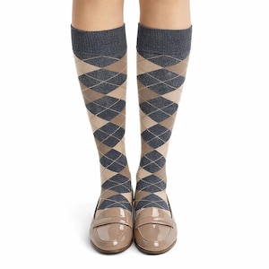 May include: Knee-high argyle socks in gray, navy, and tan, paired with tan patent leather loafers. The socks feature a classic diamond pattern. The shoes have a glossy finish and a low heel. The image is set against a white background.