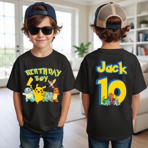May include: Black t-shirt with a colorful graphic of cartoon characters and the text "BIRTHDAY BOY" on the front. The back of the shirt has the name "Jack" and the number "10" in yellow and blue.