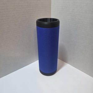 Puede incluir: Un soporte azul aislado para bebidas con una superficie texturizada. El soporte tiene un borde y una base negros. El soporte cilíndrico está diseñado para mantener las bebidas frías. El producto se muestra sobre un fondo neutro.