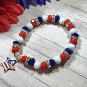 Pu&ograve; includere: Un braccialetto patriottico con perline rosse, bianche e blu, rifinito con distanziatori argentati. Un ciondolo a forma di stella dorata con un design a bandiera americana pende dal braccialetto, perfetto per mostrare il tuo orgoglio americano.
