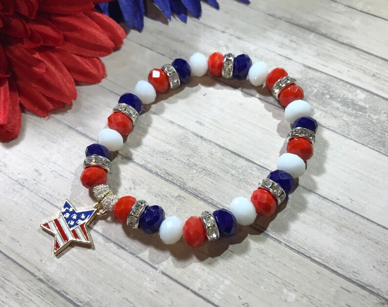Pu&ograve; includere: Un braccialetto patriottico con perline rosse, bianche e blu, rifinito con distanziatori argentati. Un ciondolo a forma di stella dorata con un design a bandiera americana pende dal braccialetto, perfetto per mostrare il tuo orgoglio americano.