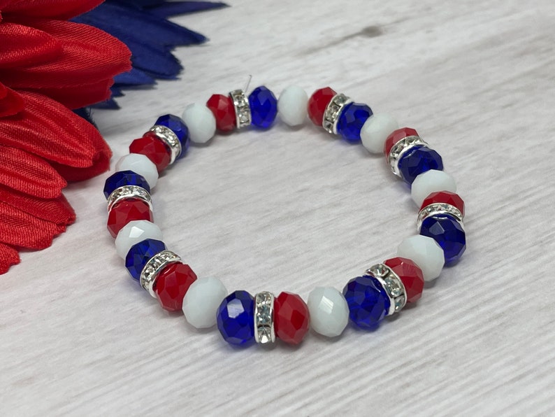 Puede incluir: Pulsera de cuentas rojas, blancas y azules, con separadores plateados. Las cuentas son facetadas. La pulsera el&aacute;stica parece hecha a mano, con tem&aacute;tica patri&oacute;tica.