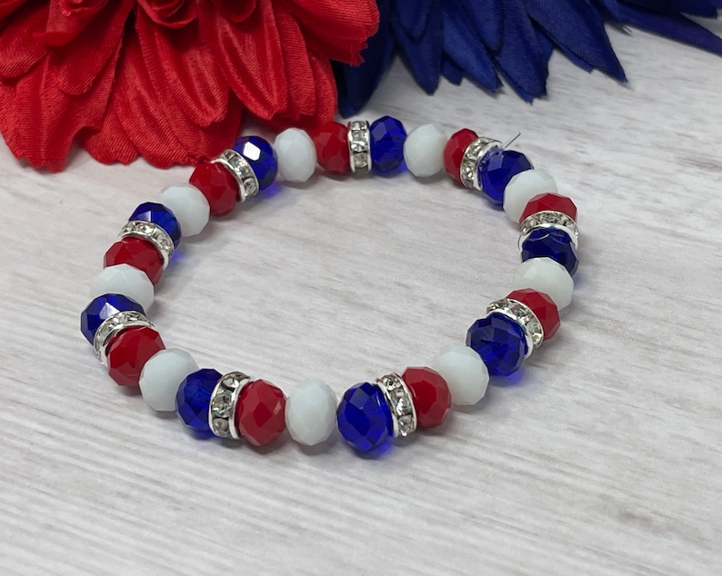 Puede incluir: Una pulsera de cuentas rojas, blancas y azules facetadas, intercaladas con espaciadores plateados incrustados con pedrer&iacute;a transparente. Un accesorio patri&oacute;tico, ideal para a&ntilde;adir un toque de color.